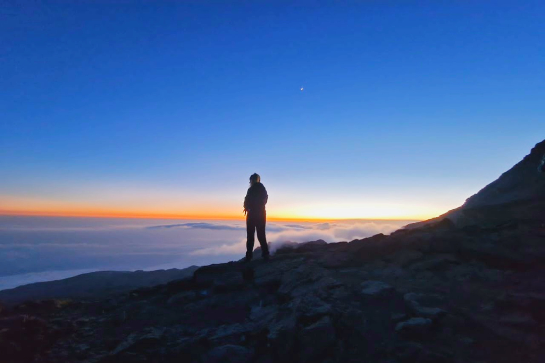Una persona in piedi sul Kilimangiaro durante l'alba