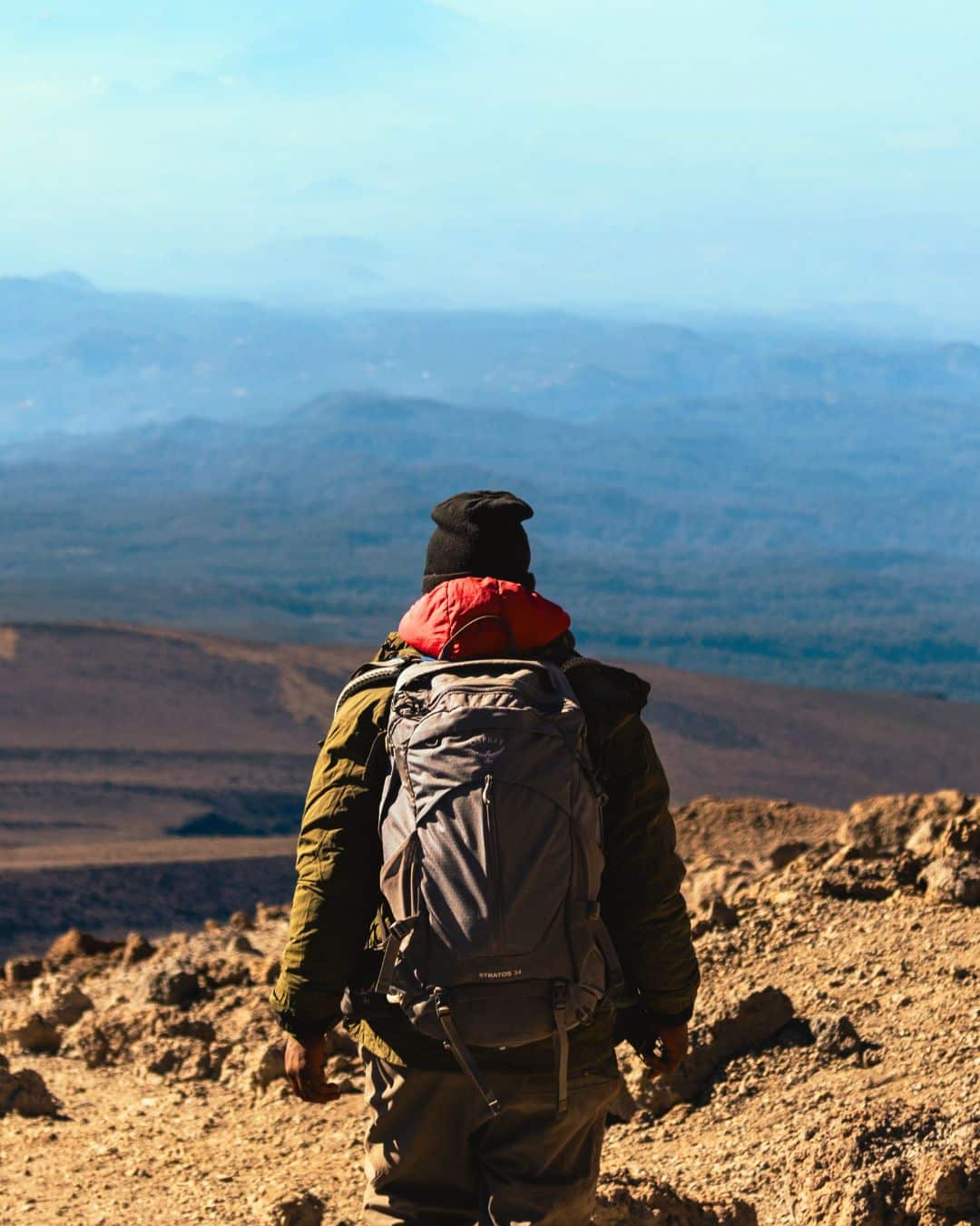 Neatly organized camping gear, including a backpack, water bottle, shoes, and other outdoor essentials