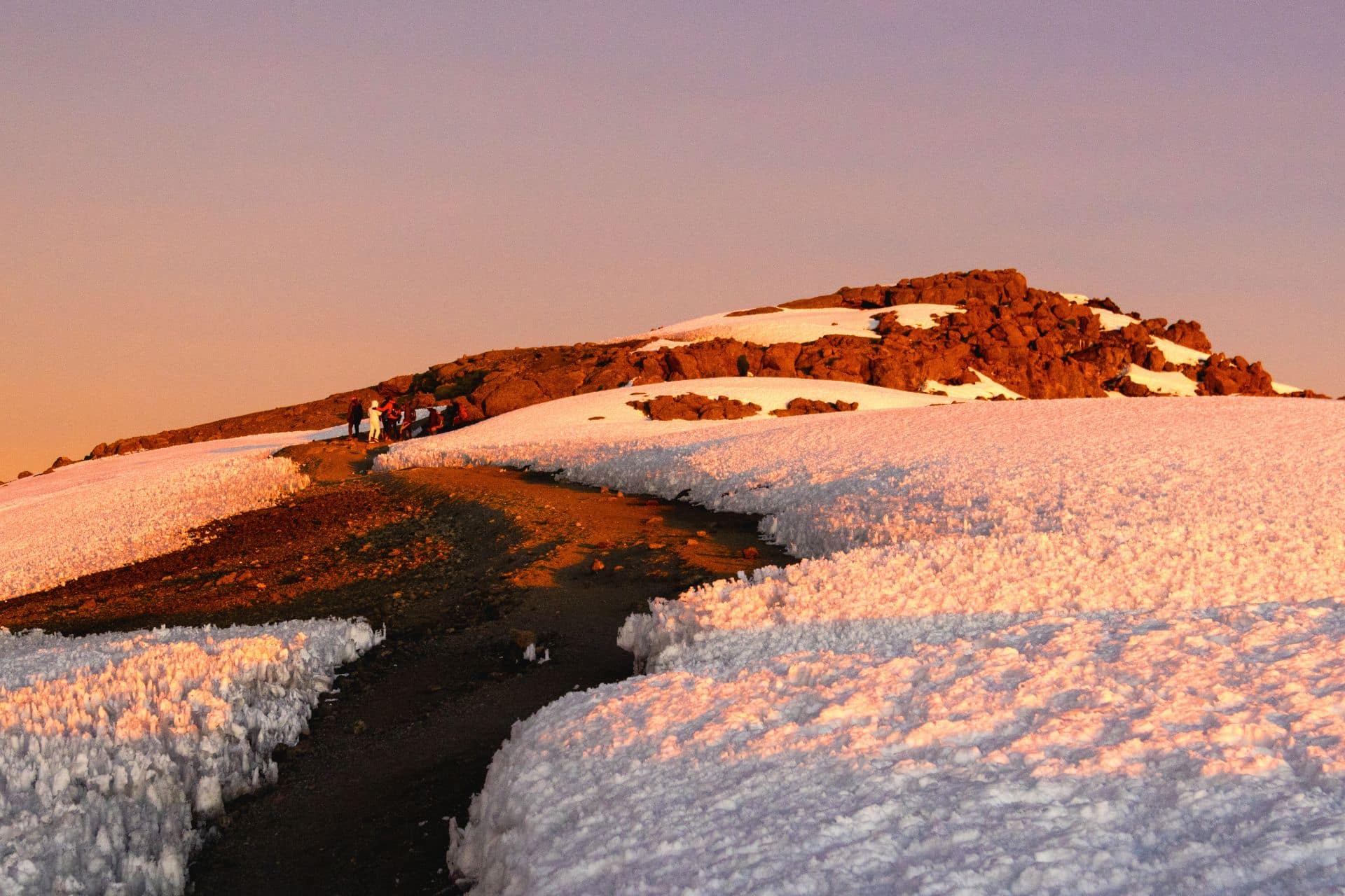 Snow-covered slopes near the summit of Mount Kilimanjaro during sunrise in Tanzania